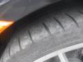 Close-up of a tire and wheel from a 2016 Porsche Boxster showcasing the tire tread pattern and markings on the sidewall