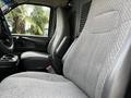 A 2015 Chevrolet Express with gray fabric seating in the front, featuring two high-backed seats and a center console