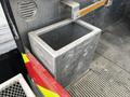 A metal tool box located in the bed of a 2007 Ford F-550 with a rectangular shape and open top