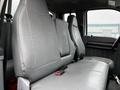 Interior view of a 2013 Ford F-650 showcasing the gray bench seat with a simple design and seatbelt in a clean and minimalistic style