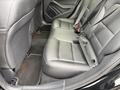 The interior of a 2016 Mercedes-Benz GLA-250 showing black leather rear seats with seatbelts and floor mats