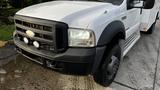 A white 2007 Ford F-550 truck with a black grill and round headlights featuring mounted fog lights on the front bumper