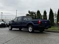 A blue 2008 Ford F-250 Super Duty truck with four doors and a bed viewed from the rear angle