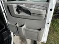 Interior door panel of a 2015 Chevrolet Express featuring a gray armrest and multiple storage compartments