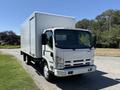 2012 Isuzu NPR HD truck with a white box-style cargo area and a silver front grille parked on a paved surface