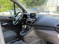 Interior view of a 2021 Ford Transit Connect showcasing the steering wheel dashboard gear shift and infotainment screen