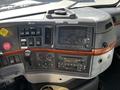Dashboard of a 2005 Volvo VND 122 featuring various control buttons a monitor and a CD player