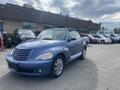 A light blue 2007 Chrysler PT Cruiser with a convertible top parked in a parking lot showcasing its distinctive rounded design and chrome wheels