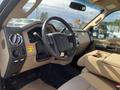 Interior view of a 2014 Ford F-350 SD showing the steering wheel dashboard and seats in beige upholstery
