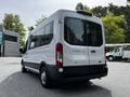 A white 2022 Ford Transit van viewed from the rear showcasing its large rear windows and sliding side door design