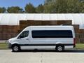 A 2023 Mercedes-Benz Sprinter van with a white exterior and dark windows is parked on a driveway