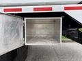A silver aluminum storage compartment mounted on the side of a 2016 Peterbilt 348 truck with a textured interior