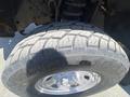 Close-up of a rugged tire on a 2016 Ford F-350 SD showcasing deep treads and a shiny silver rim