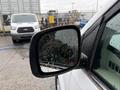 A 2017 Dodge Grand Caravan's side mirror is shown with droplets of water on its surface