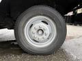 Close-up of a 2012 Ford Econoline wheel featuring a silver rim and a Bridgestone tire with multiple lug nuts visible