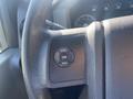 A close-up of the steering wheel controls of a 2014 Ford F-250 SD featuring buttons labeled setup info and reset