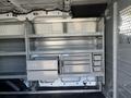 Interior of a 2016 Ford Transit van with metal shelving units and storage drawers arranged for utility use