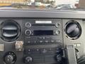 Dashboard of a 2015 Ford F-250 SD featuring a stereo system control panel with knobs and buttons for audio settings and climate control
