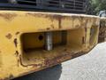 Close-up of a 2010 John Deere 444K heavy machinery front plate showing scratches and rust around the attachment point