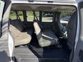 Interior view of a 2021 Chevrolet Express showing two rows of seats in a van configuration with seat belts visible