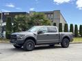 A 2019 Ford F-150 in a metallic gray finish with black accents large wheels and off-road tires parked in a lot