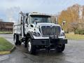 A 2011 International WorkStar truck with a white body and black front grill featuring chrome accents and lights on top, positioned on a paved surface