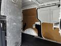 Interior view of a 2014 Ford Transit Connect with metal shelving installed against wooden paneling and a black rubber floor