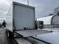 A white 2019 Hino 338 24 foot cube truck with an open rear door and a loading ramp extended down