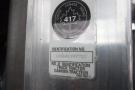 A close-up of a metal identification plate on a 2015 Kenworth T660 truck displaying a transport symbol and details including identification number