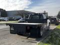 A 2017 Chevrolet Silverado 3500HD with a flatbed design and a black metal rear guard parked on the street