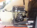 A 2008 JLG Boom Lift with hydraulic control valves and connected hoses in the machinery compartment