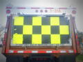A 2016 International WorkStar 7500 truck with a large checkerboard pattern on the rear and a cautionary message about visibility regarding mirrors