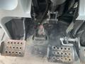 Foot pedals of a 2016 New Holland T475 tractor showing two metal pedals with holes and a gear shifter between them