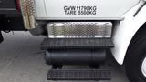 A black step platform with a perforated surface mounted on the side of a white 2015 International DuraStar 4300 truck