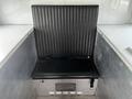 A black ribbed vinyl seat with seatbelt in a vehicle interior with a diamond plate storage compartment underneath