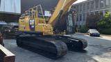 A 2018 Caterpillar 326F L Excavator with a yellow body and black tracks is parked on a surface with visible treads on the ground and machinery components in the upper section