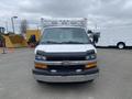 A 2014 Chevrolet Express van with a white exterior and a prominent Chevrolet emblem on the front grille