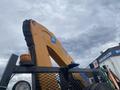 A 2017 Ford F-550 with an extended yellow boom arm attached to its rear and an orange light on top of the cab