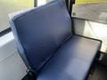 A blue upholstered seat from a 2018 Chevrolet Express van positioned against a window with a textured fabric design