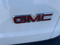 Close-up of the chrome GMC logo on a white 2012 GMC Savana van