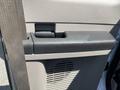 The interior door handle of a 2008 Ford F-450 SD with a textured grip and a panel featuring air vents