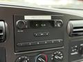 Dashboard of a 2007 Ford F-550 featuring a radio with digital clock display and various control knobs for volume and air conditioning