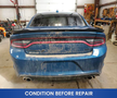 A blue 2022 Dodge Charger with a dirty exterior is positioned in a garage setting