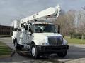A 2011 International 4300 truck with a white body and a large elevated boom arm for maintenance work on utility lines