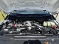 The engine compartment of a 2023 Ford F-550 showcasing the engine and various components such as hoses wires and cooling system elements