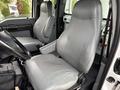 Interior view of a 2015 Ford F750 with two gray upholstered seats and a steering wheel in the foreground