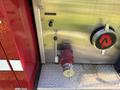 A close-up of a red valve handle and control lever on the side of a 1994 Volvo FE 42 fire truck with metallic surface details