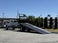 A 2018 International DuraStar tow truck with a lowered ramp ready for loading vehicles