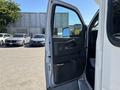 A 2017 Chevrolet Express with an open driver side door showcasing the interior panel and controls
