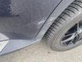 A 2009 BMW X5 with a scratched lower side panel and a close-up view of a black tire with a patterned tread